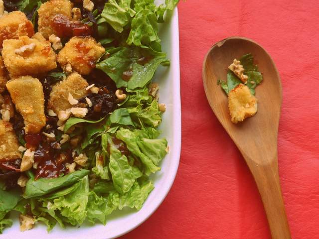 Ensalada de verdes, queso brie frito y cebolla caramelizada