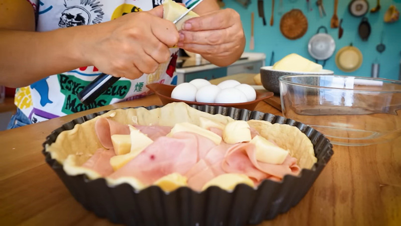 Preparación de pascualina con relleno de jamón y queso